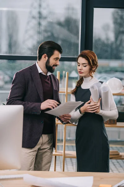 Two architects discussing documents and blueprints in office — Stock Photo