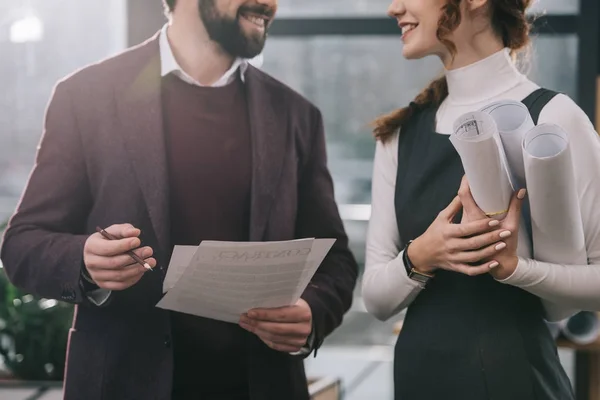 Cropped view of architects discussing blueprints and documents in office — Stock Photo