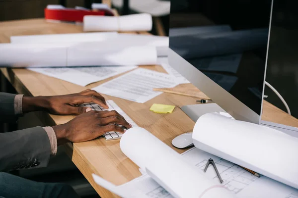 Schnappschuss eines Architekten, der am chaotischen Arbeitsplatz mit dem Computer arbeitet — Stockfoto