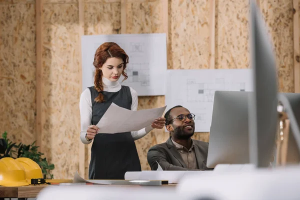 Arquitectos discutiendo plan de construcción mientras trabajan en la oficina - foto de stock
