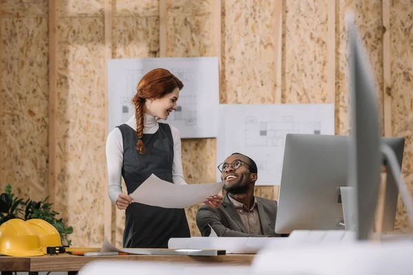 Jeunes architectes discutant du plan de construction tout en travaillant au bureau — Photo de stock