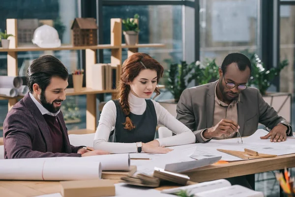 Equipo multiétnico de arquitectos que trabajan juntos en la oficina moderna - foto de stock