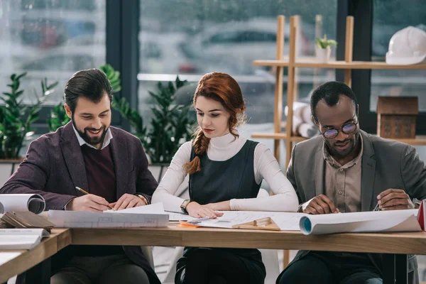 Feliz equipo joven de arquitectos de trabajo en la oficina - foto de stock