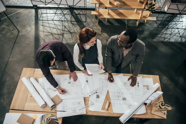High angle view of team of architects working with building plans at office — Stock Photo