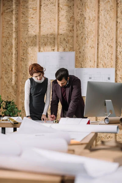 Junge Architekten diskutieren im Büro über Baupläne — Stockfoto