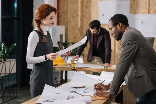 Équipe concentrée d'architectes travaillant ensemble dans un bureau moderne — Photo de stock