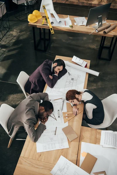 Vue grand angle de l'équipe épuisée d'architectes dormant au bureau — Photo de stock