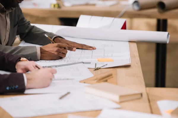 Plano recortado de arquitectos dibujando planos de edificios juntos en la oficina - foto de stock