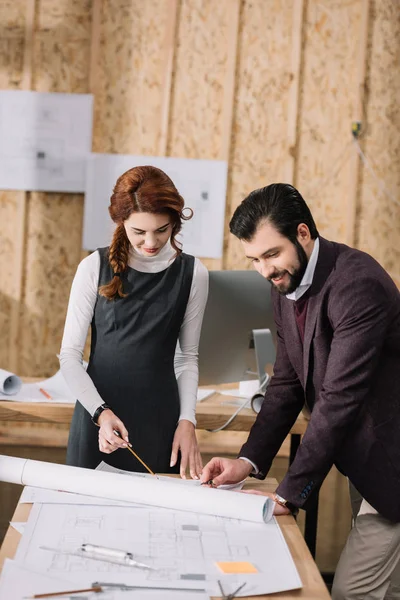 Young architects discussing architectural plans at modern office — Stock Photo