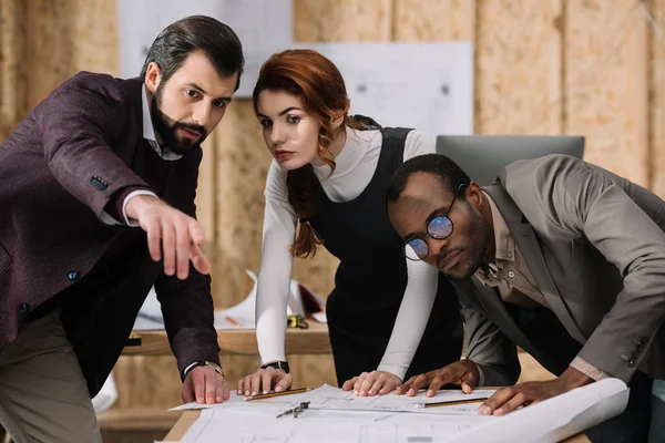 Young multiethnic team of architects discussing projects — Stock Photo