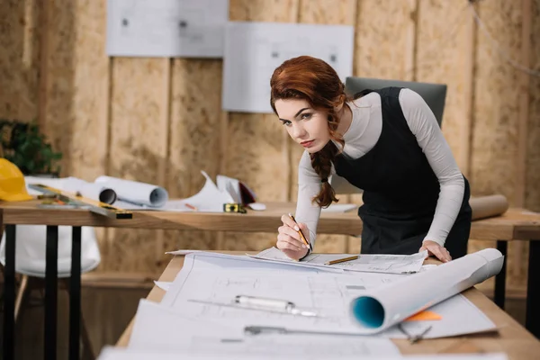 Bella giovane architetto donna alla scoperta di piani di costruzione — Foto stock