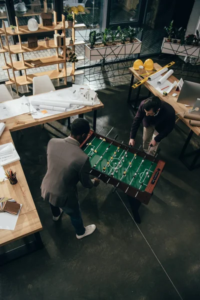 Vue grand angle des architectes multiethniques jouant au baby-foot au bureau — Photo de stock