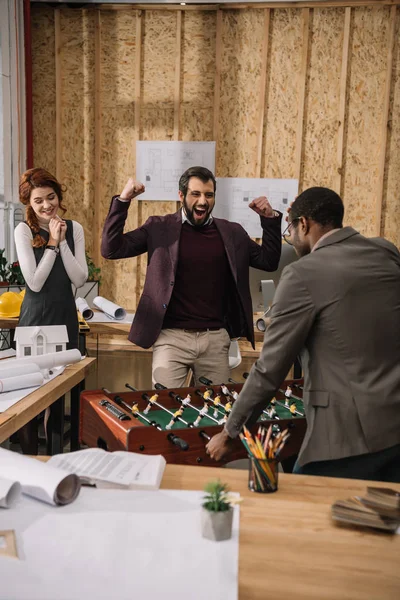 Jeunes architectes jouant au baby-foot au bureau moderne — Photo de stock