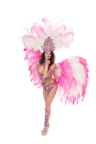 Mujer posando en traje de carnaval con plumas rosadas soplando beso, aislado en blanco - foto de stock