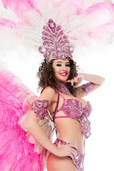 Mujer sonriente posando en traje de carnaval con plumas rosas y gemas, aislada en blanco - foto de stock