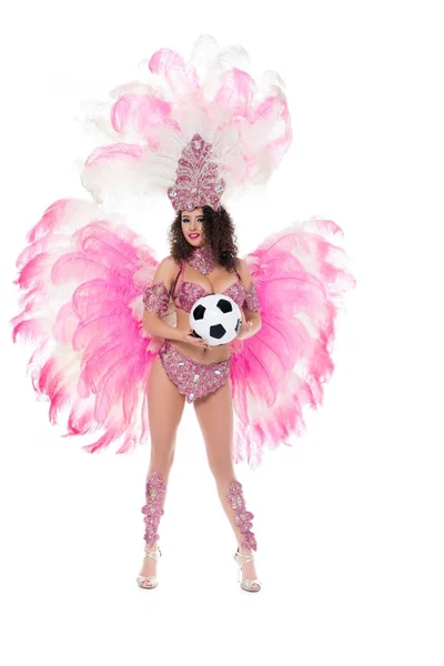 Жінка в карнавальному костюмі з рожевим пір'ям, що тримає футбольний м'яч, ізольована на білому — стокове фото