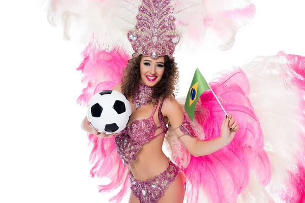 Lächelnde Frau im Karnevalskostüm mit Fußballball und brasilianischer Flagge, während sie in die Kamera blickt, isoliert auf weiß — Stockfoto