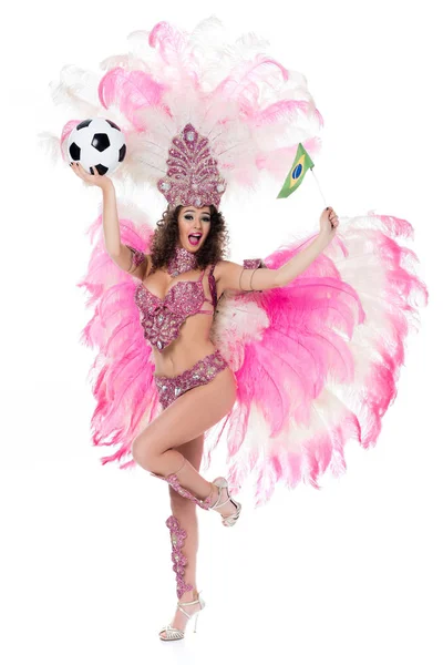 Sorrindo mulher em traje de carnaval segurando bola de futebol e bandeira brasileira enquanto olha para a câmera, isolada no branco — Fotografia de Stock