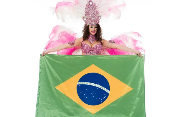 Bright woman in carnival costume with pink feathers holds large flag of Brasil isolated on white — Stock Photo