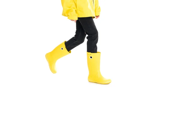 Vue partielle de la femme en imperméable jaune et bottes de pluie isolées sur blanc — Photo de stock