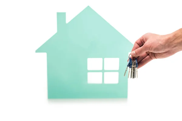 Plan recadré de la main masculine avec des clés et modèle de maison isolé sur blanc — Photo de stock