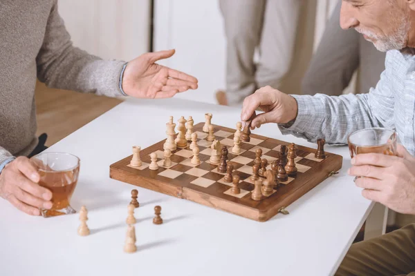 Imagem cortada de homens jogando xadrez enquanto sentados à mesa — Fotografia de Stock