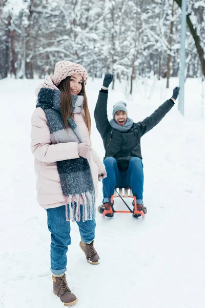 Jovem casal trenó juntos no dia de inverno no parque — Fotografia de Stock