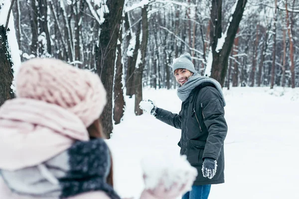 Jovem casal se divertindo juntos na floresta nevada — Fotografia de Stock