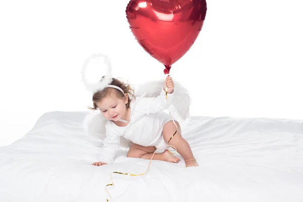 Маленький ангел с крыльями и нимбом, держащий сердечный шар, изолированный на белом — стоковое фото