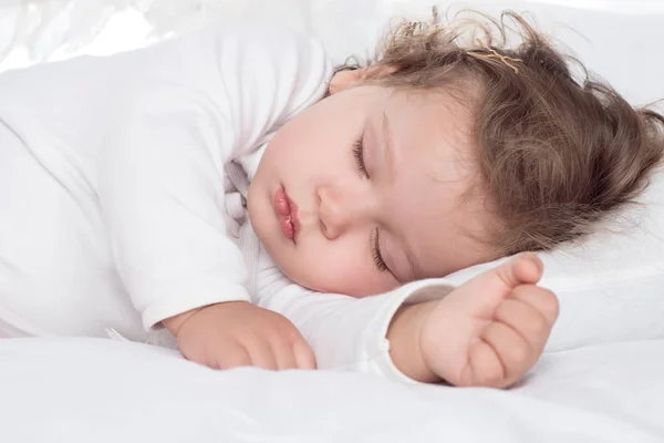 Kleines entzückendes Mädchen, das auf dem Bett schläft — Stockfoto