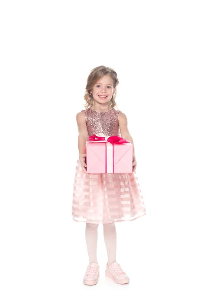 Smiling kid in dress with sparkles holding present, isolated on white — Stock Photo
