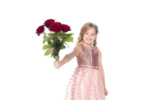 Adorable smiling kid in dress holding bouquet of red roses, isolated on white — Stock Photo