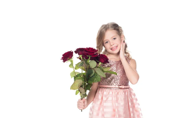 Чарівна дитина в сукні тримає букет з червоних троянд, ізольована на білому — стокове фото