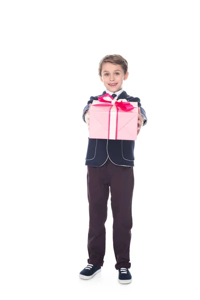 Adorable elegante niño sosteniendo caja de regalo y sonriendo a la cámara aislada en blanco - foto de stock