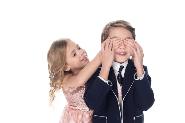 Beautiful smiling little girl closing eyes to happy little boy isolated on white — Stock Photo