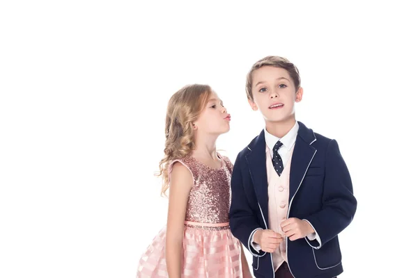 Schöne kleine Mädchen in der Lage zu küssen Junge im Anzug Blick auf Kamera isoliert auf weiß — Stockfoto