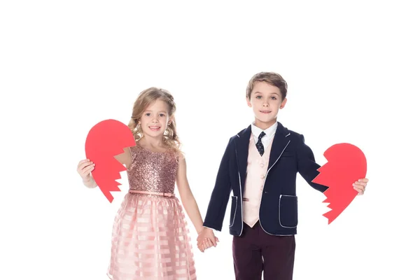 Cute little kids holding pieces of broken heart symbol and smiling at camera isolated on white — Stock Photo