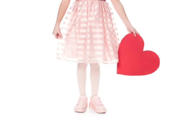 Cropped shot of little child in pink dress holding red heart symbol isolated on white — Stock Photo