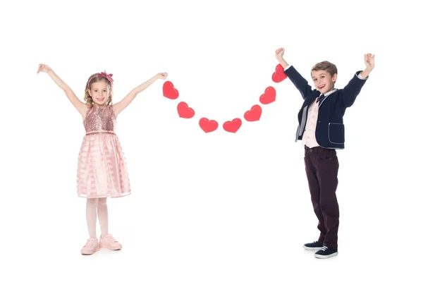 Happy stylish children holding red hearts and smiling at camera isolated on white — Stock Photo