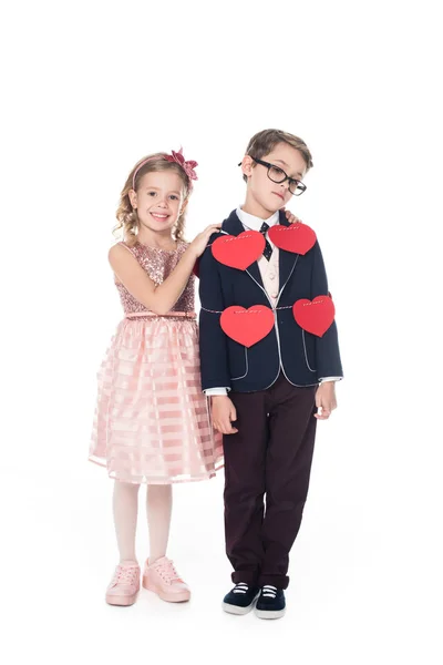 Happy little girl embracing upset boy tied with rope and red hearts isolated on white — Stock Photo