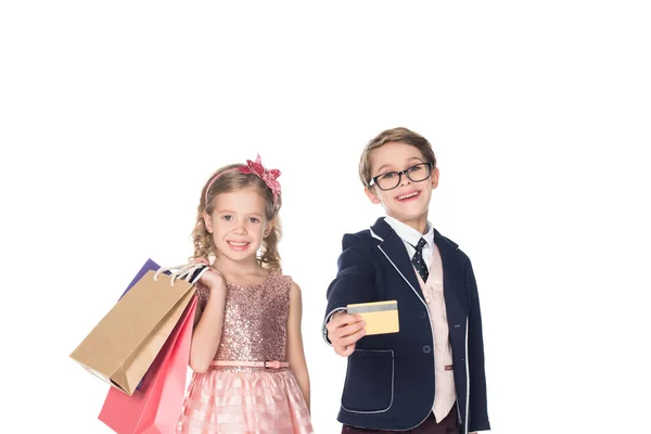 Красиві стильні діти з сумками і кредитною карткою посміхаються на камеру ізольовані на білому — стокове фото