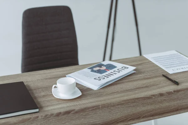 Tasse et journal d'affaires sur la table sur gris — Photo de stock