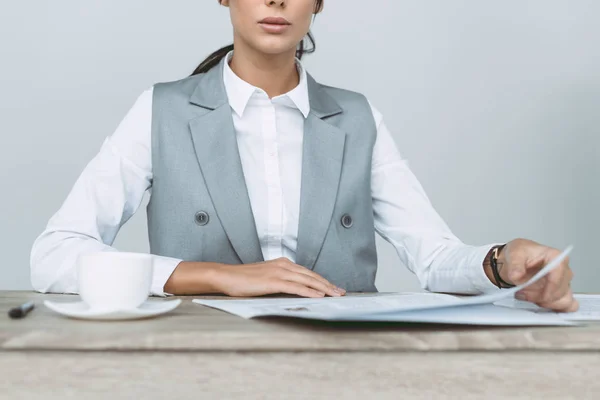 Cropped image of businesswoman reading newspaper isolated on gray — Stock Photo