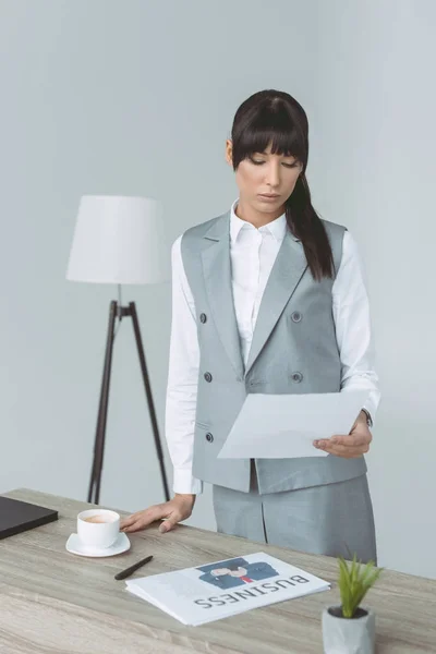 Femme d'affaires regardant document isolé sur gris — Photo de stock
