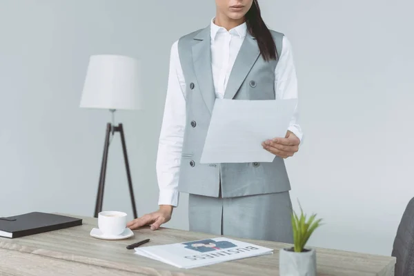 Imagen recortada de la mujer de negocios sosteniendo documento aislado en gris - foto de stock