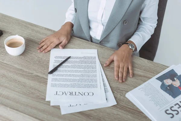 Imagem cortada de empresária sentada à mesa com contrato e documentos — Fotografia de Stock