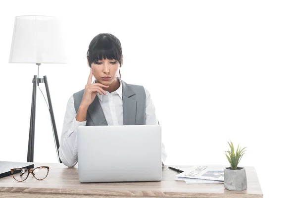 Empresária sentada à mesa e olhando para laptop isolado em branco — Fotografia de Stock