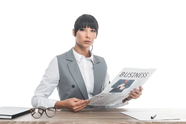 Donna d'affari seduto a tavola e tenendo giornale d'affari isolato su bianco — Foto stock