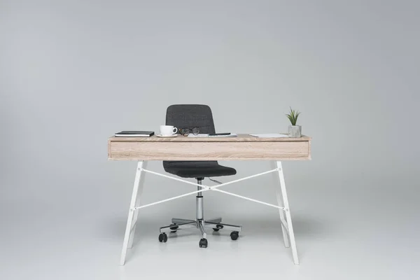 Table de bureau avec chaise vide sur gris — Photo de stock