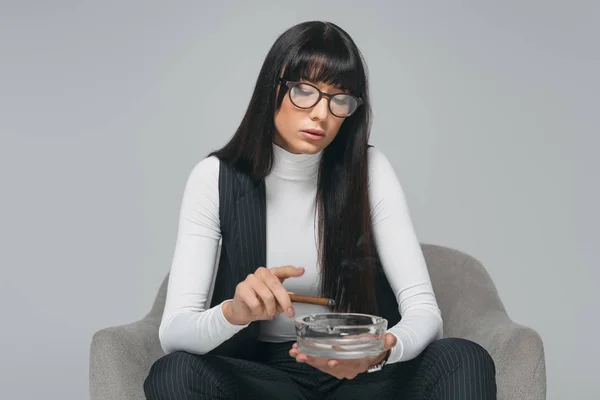 Atractiva morena mujer de negocios fumar aislado en gris - foto de stock